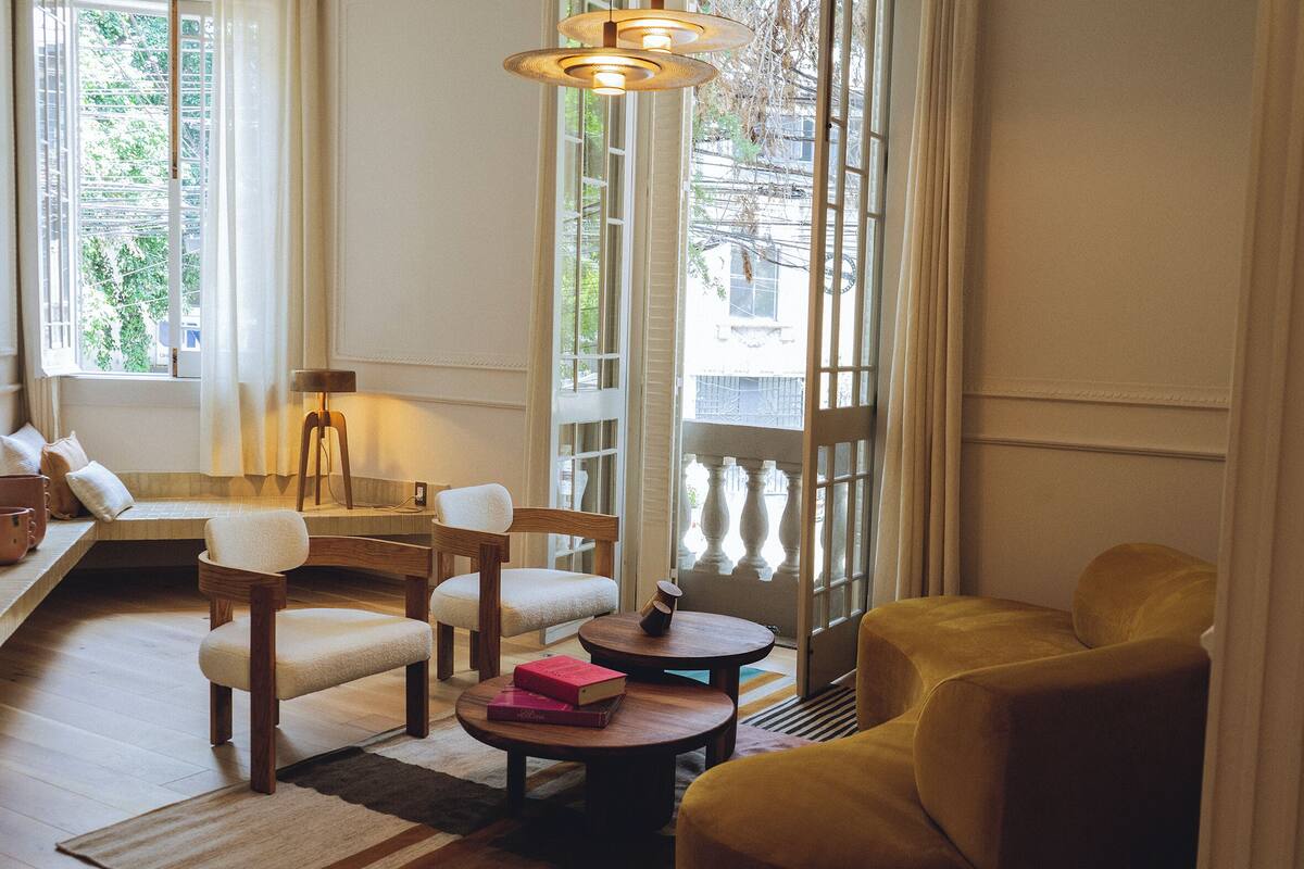 A cozy living room with a sofa, chairs, a coffee table, and a bookshelf.