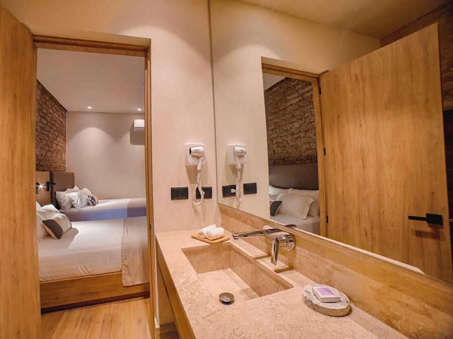 Un baño moderno con un espejo grande, un lavabo y un secador de pelo.