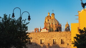 A historic building with a prominent dome and bell tower, surrounded by stone walls and a street lamp. - Hotel Casa Aranzazu San Luis Potosi (San Luis Potosi)
