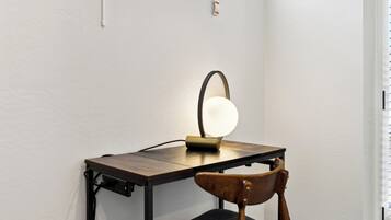 A desk with a lamp, a chair, and a power outlet.