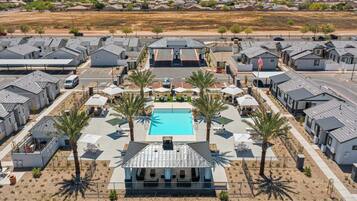 Alberca al aire libre, sombrillas en la alberca y camastros