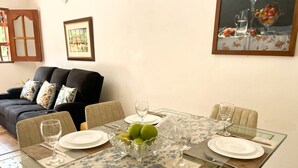 A dining area with a glass table, chairs, and a vase of green apples. - El Pinar House: Tranquility, Family, and Nature (Jardín)