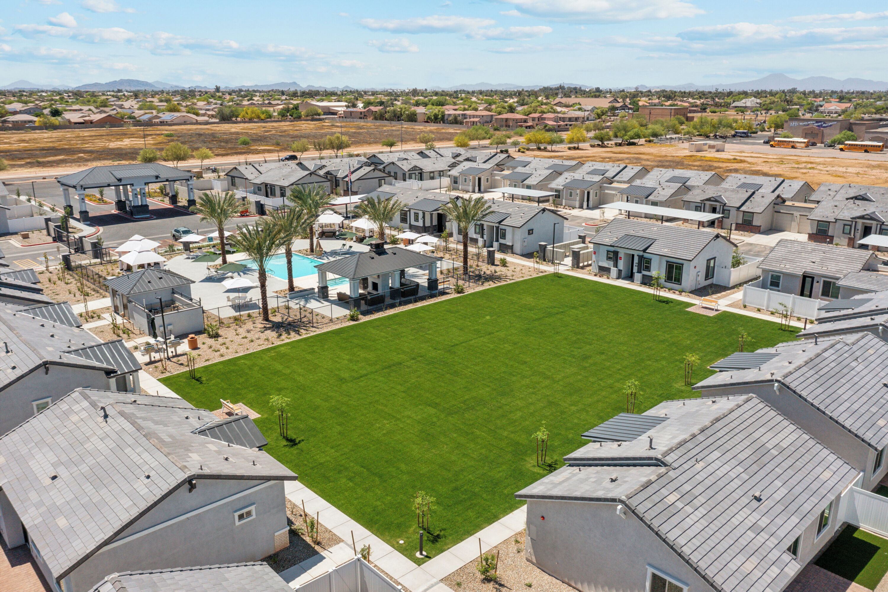 Un quartier résidentiel comprenant plusieurs maisons de ville, une piscine et une pelouse bien entretenue.