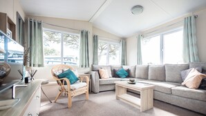 A cozy living room with a sofa, a chair, a coffee table, and a dining area with a table and chairs.