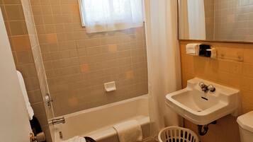 Une salle de bain équipée d’une baignoire, d’un lavabo, de toilettes et d’un rideau de douche.
