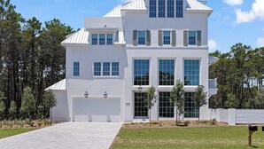 A modern two-story house with a white exterior, large windows, and a garage. - Oceanview Oasis: Luxury 6BR Home with Pool (Seagrove Beach)