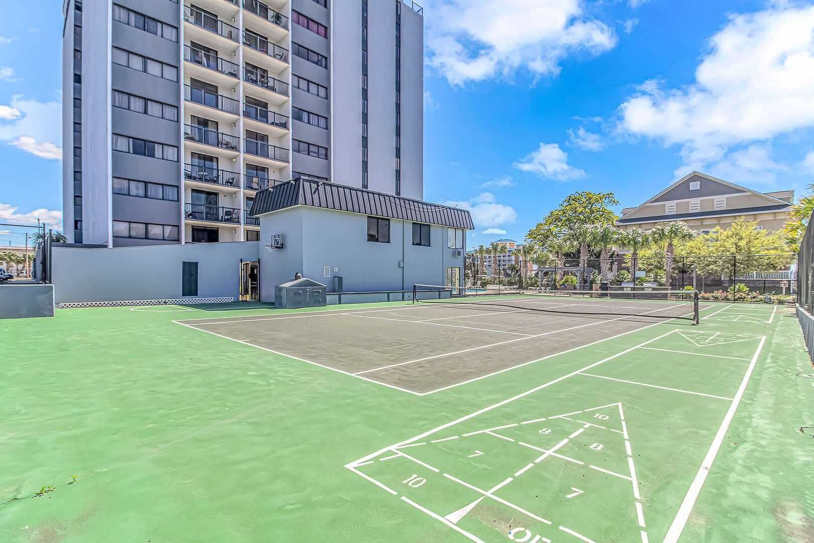 Una cancha de tenis con un edificio al fondo.