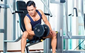 En person bruger en benpresmaskine i et fitnesscenter.