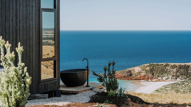 Ein modernes Gebäude mit einem großen Fenster mit Blick auf das Meer.