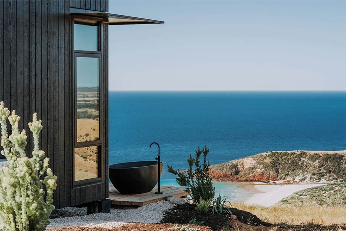 A modern building with a large window overlooking the sea.
