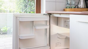 A kitchen with a built-in refrigerator, a sink, and a window with blinds. - Las Kabacki Comfy Apartment (Warszawa)