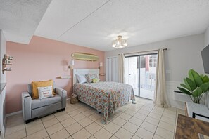 Une chambre à coucher avec un lit, un canapé, un lustre et une vue sur l’extérieur.