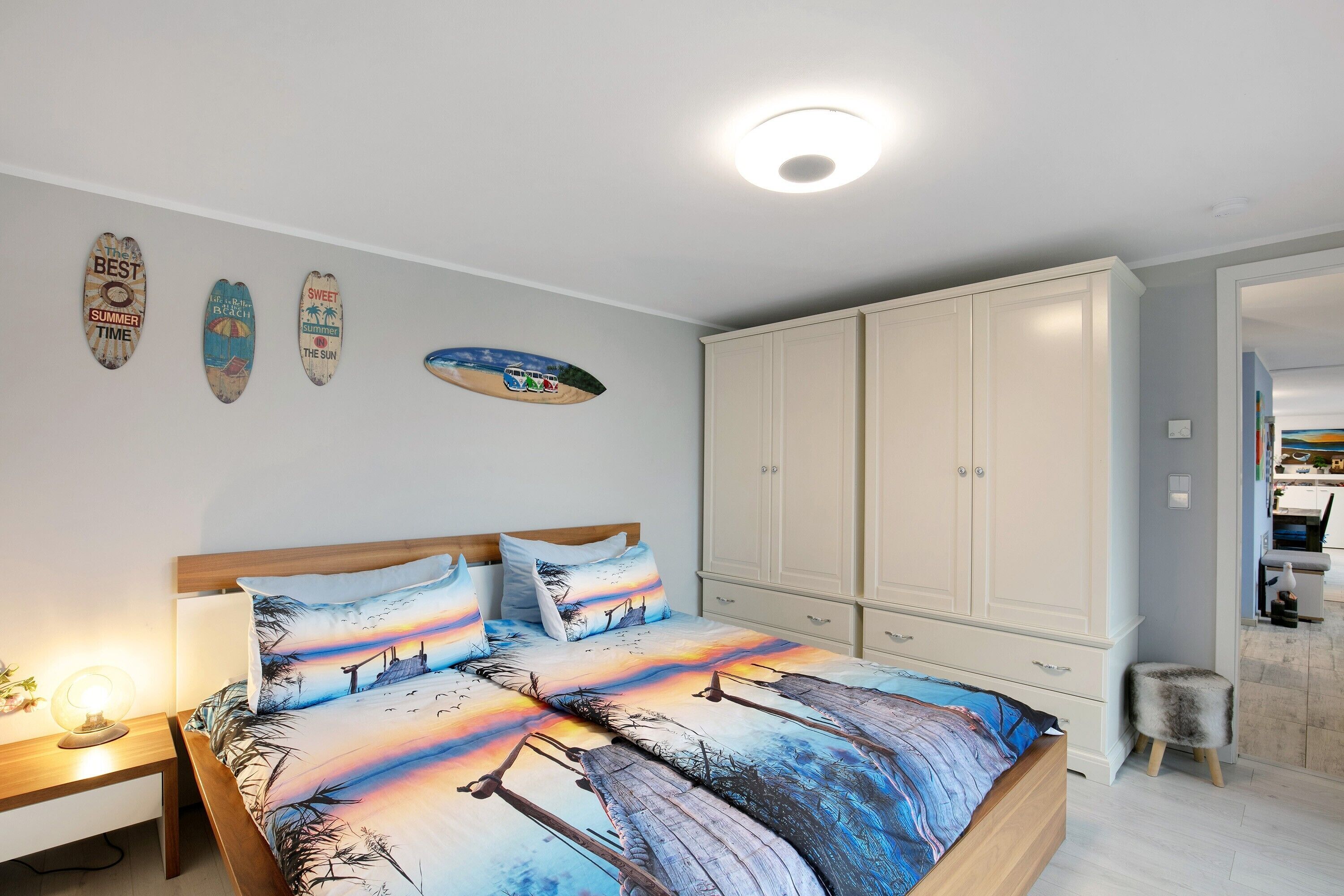 Ein Schlafzimmer mit Bett, Nachttisch, Kleiderschrank und Wanddekorationen.