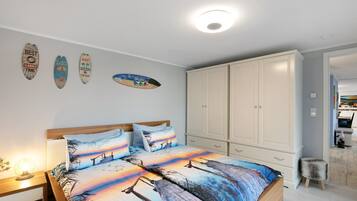 Ein Schlafzimmer mit Bett, Nachttisch, Kleiderschrank und Wanddekorationen.