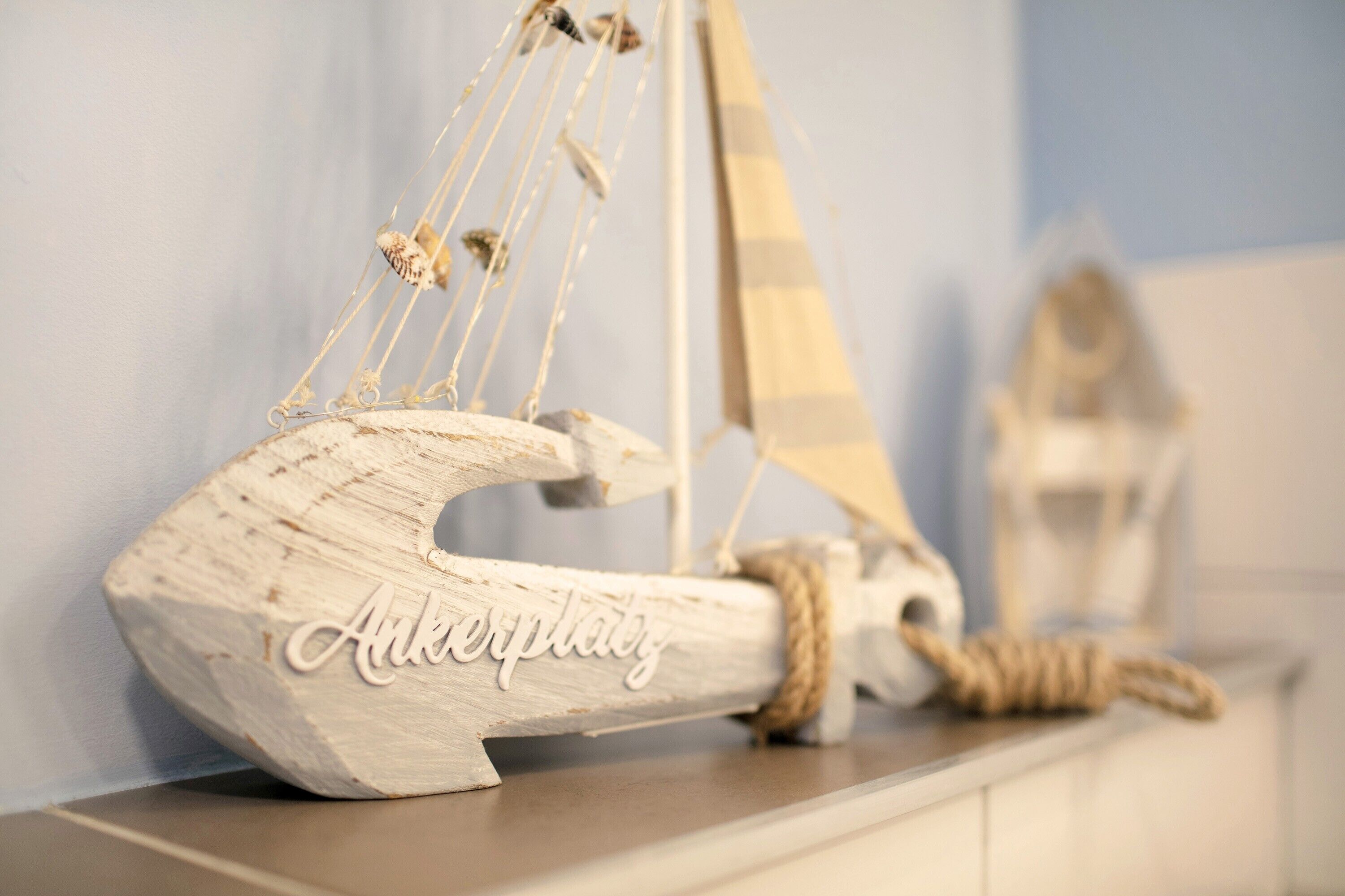 A wooden anchor with the inscription 'Ankerplay' on a shelf.