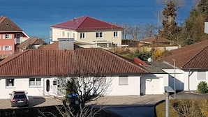 Un barrio residencial con casas, un coche y una masa de agua al fondo.