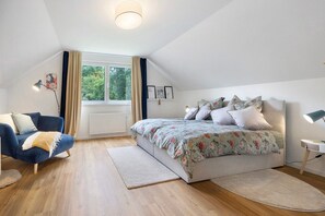 Une chambre à coucher avec un lit, un canapé, une fenêtre et un radiateur.