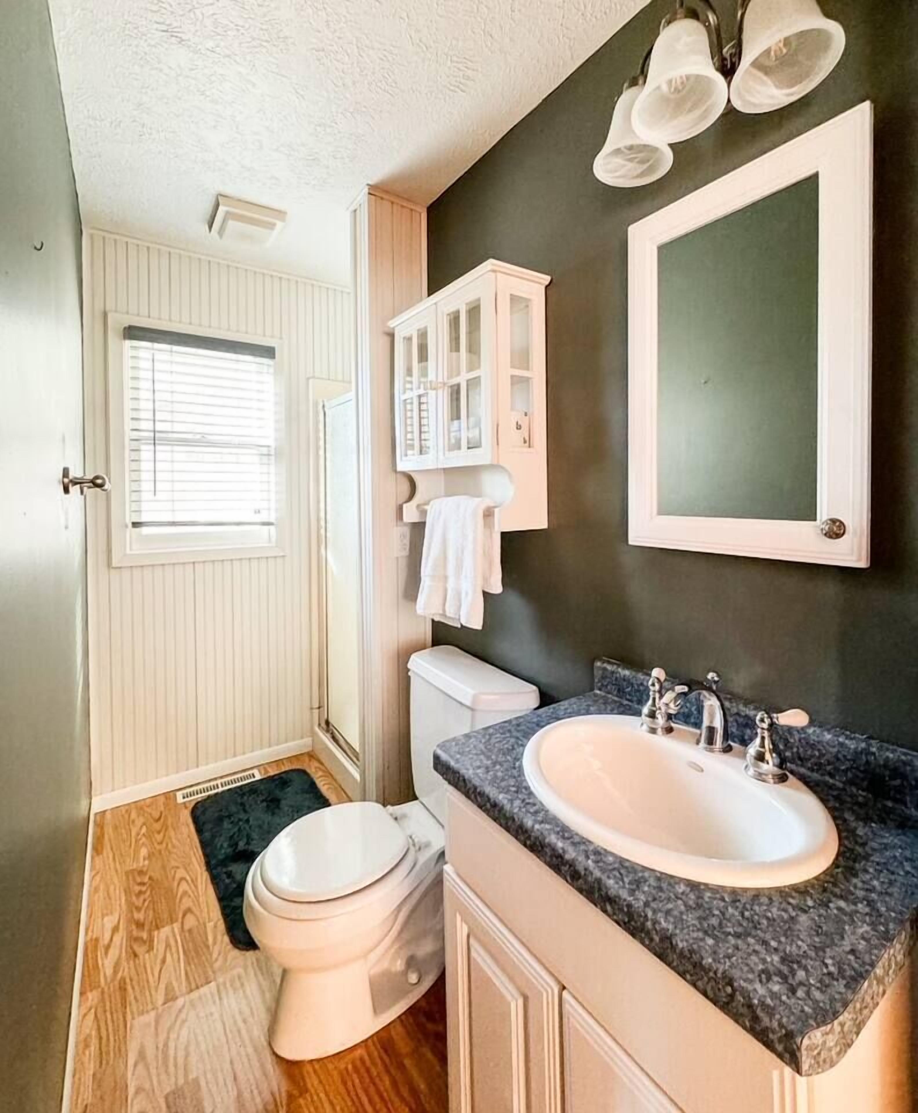 A compact bathroom with a toilet, sink, and cabinet.