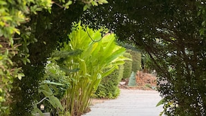 A pathway lined with lush greenery and a small structure with a light fixture. - The Canopy Krabi (Krabi)