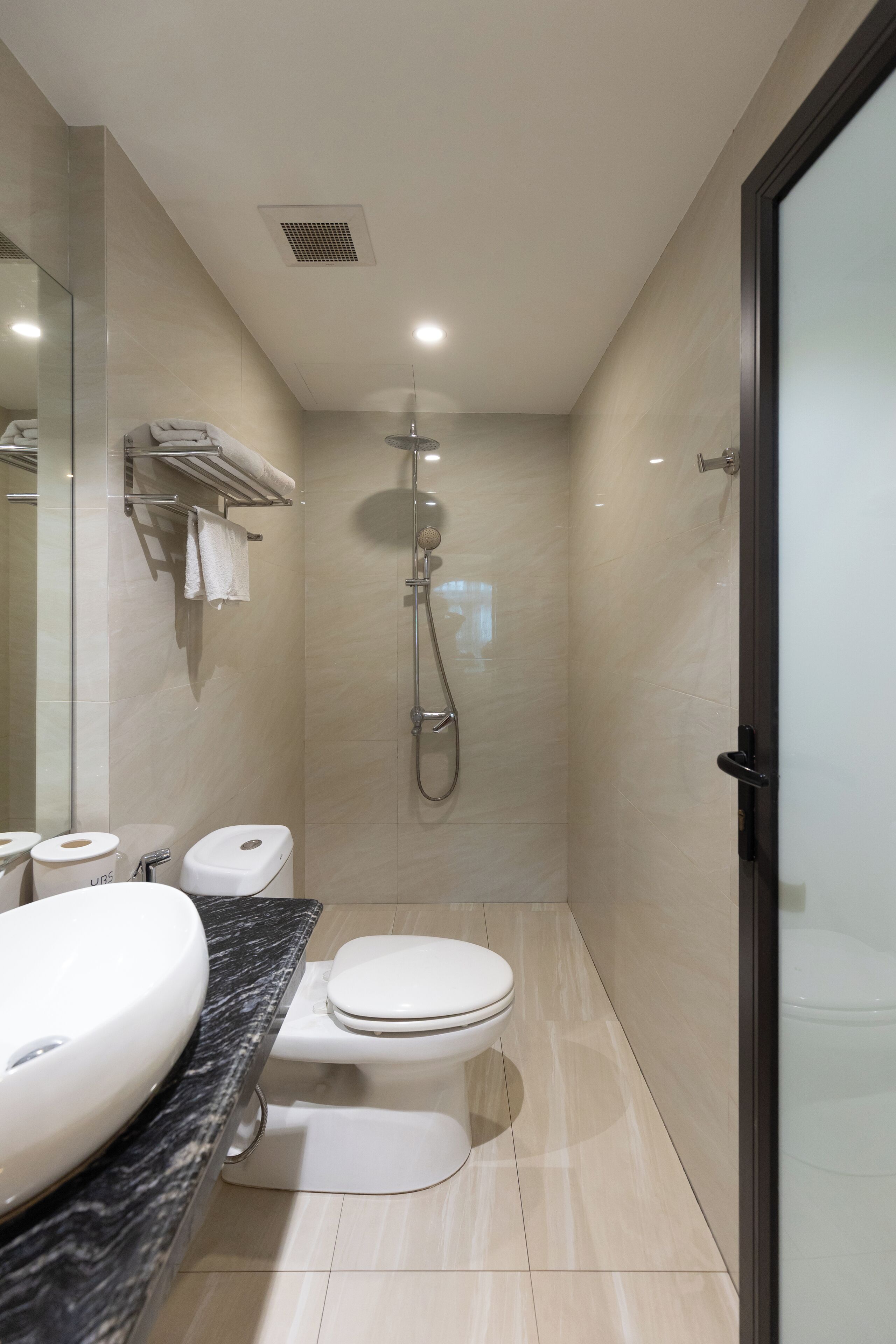 A modern bathroom with a large sink, toilet, and shower.
