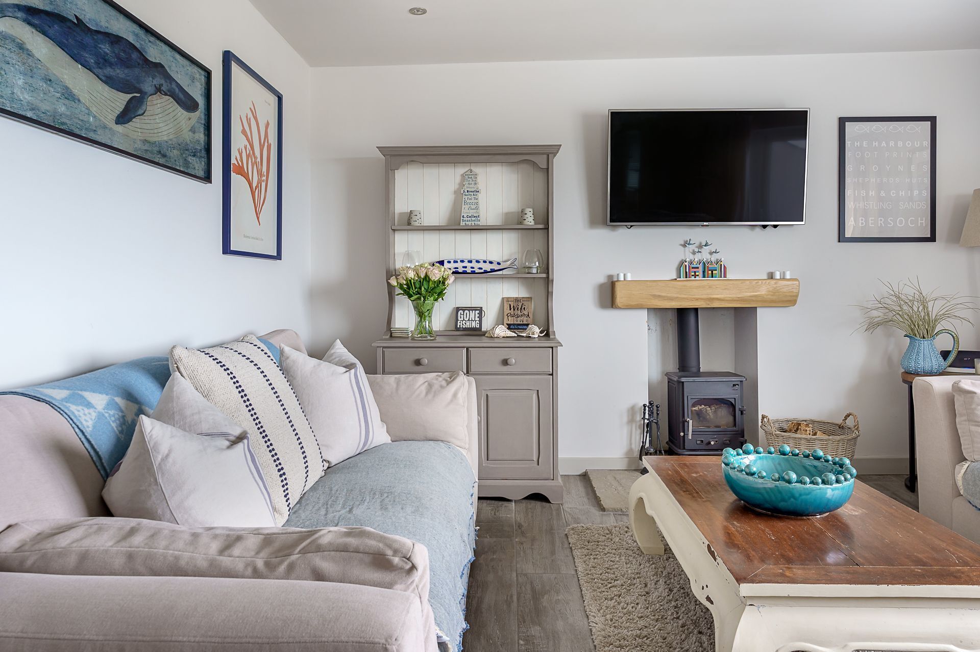 Ein gemütliches Wohnzimmer mit einer Couch, einem Holztisch, einem Fernseher und einem Kamin.