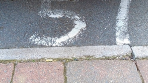 A road marking with the number '57' painted on the asphalt.