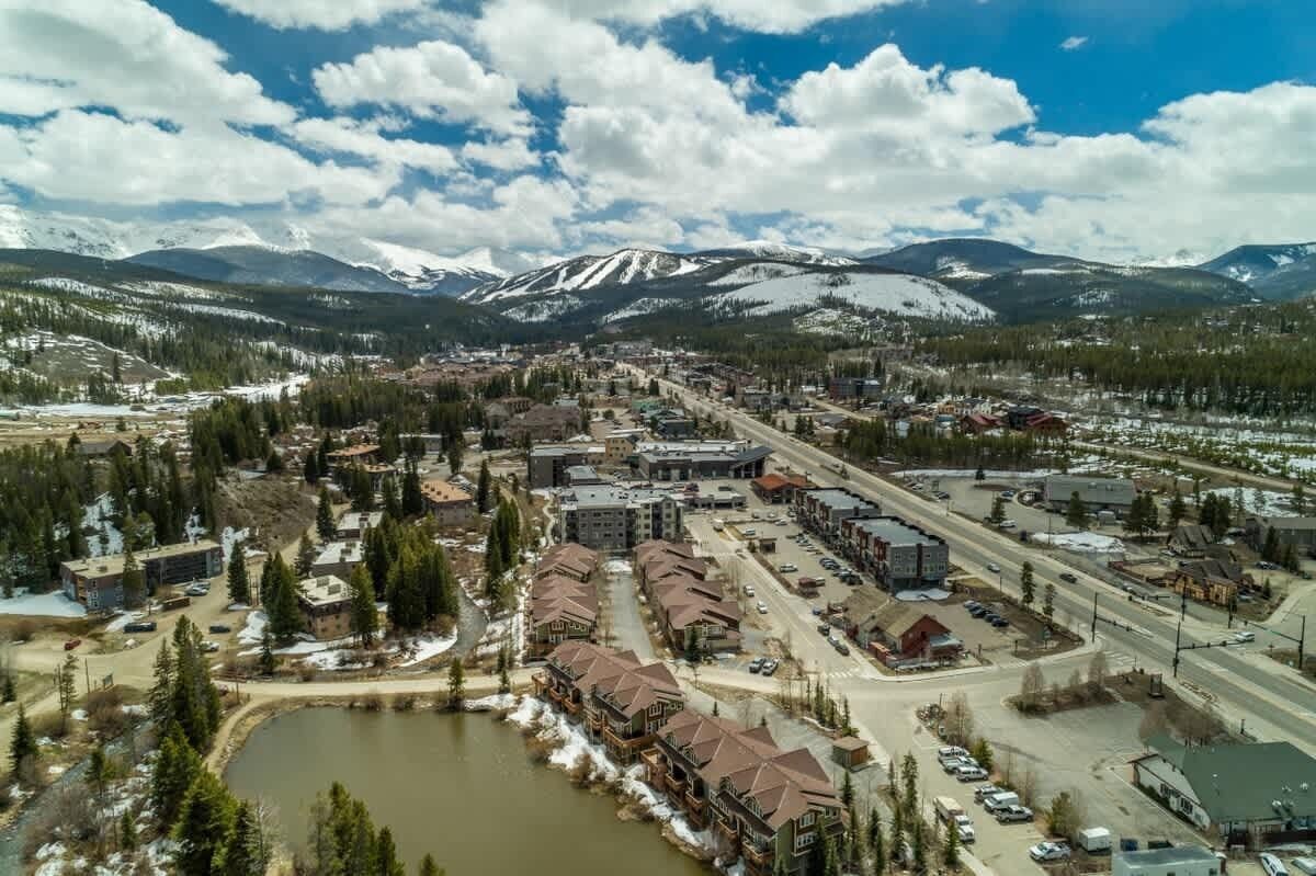 A town with a mix of commercial and residential buildings, a main road, and a body of water.