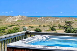 Relax in the hot tub on the deck with a serene ocean view.