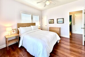 Cozy retreat with a large bed, nightstand, and shelf, perfect for a restful stay.