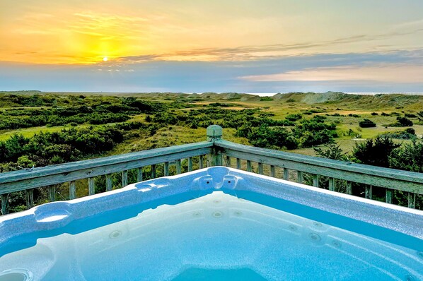 Relax on the elevated deck with a panoramic view of the serene natural landscape and unwind in the hot tub.