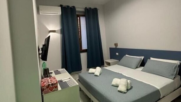 A hotel room with a bed, bedside table, and a desk with a chair. - B&B CADIFRA PORTAPICCOLA (Naples)