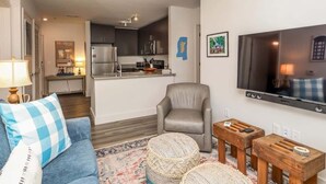 A modern living room with a sofa, a chair, a TV, and a kitchen in the background. - Rebel Run at 514 by Apex Short Term Stays (Oxford)