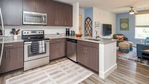 A modern kitchen with stainless steel appliances, dark wooden cabinets, and a central island. - Rebel Run at 514 by Apex Short Term Stays (Oxford)
