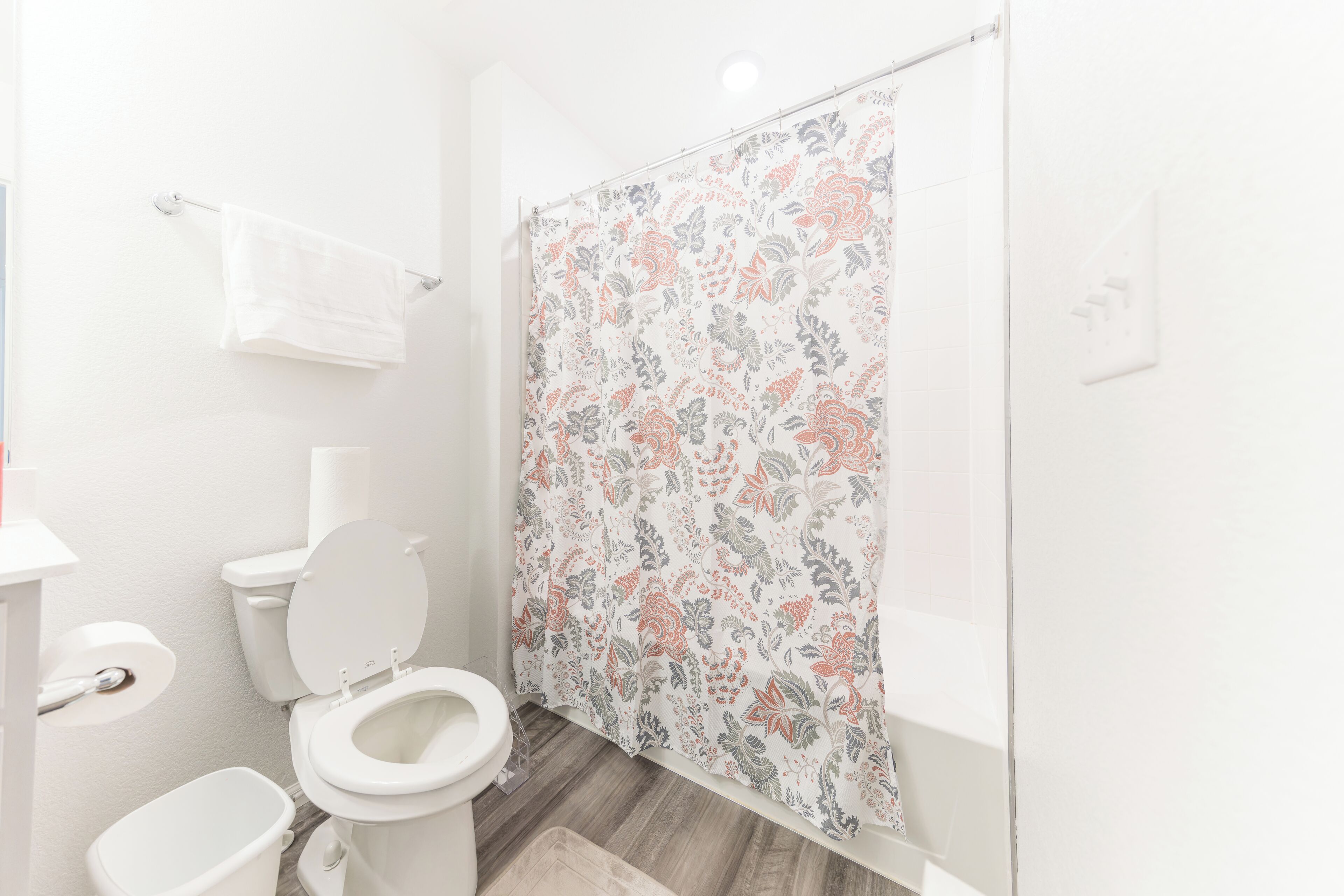 A bathroom with a toilet, bidet, and shower curtain.