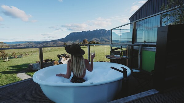 Una persona en un jacuzzi con vista a la montaña.