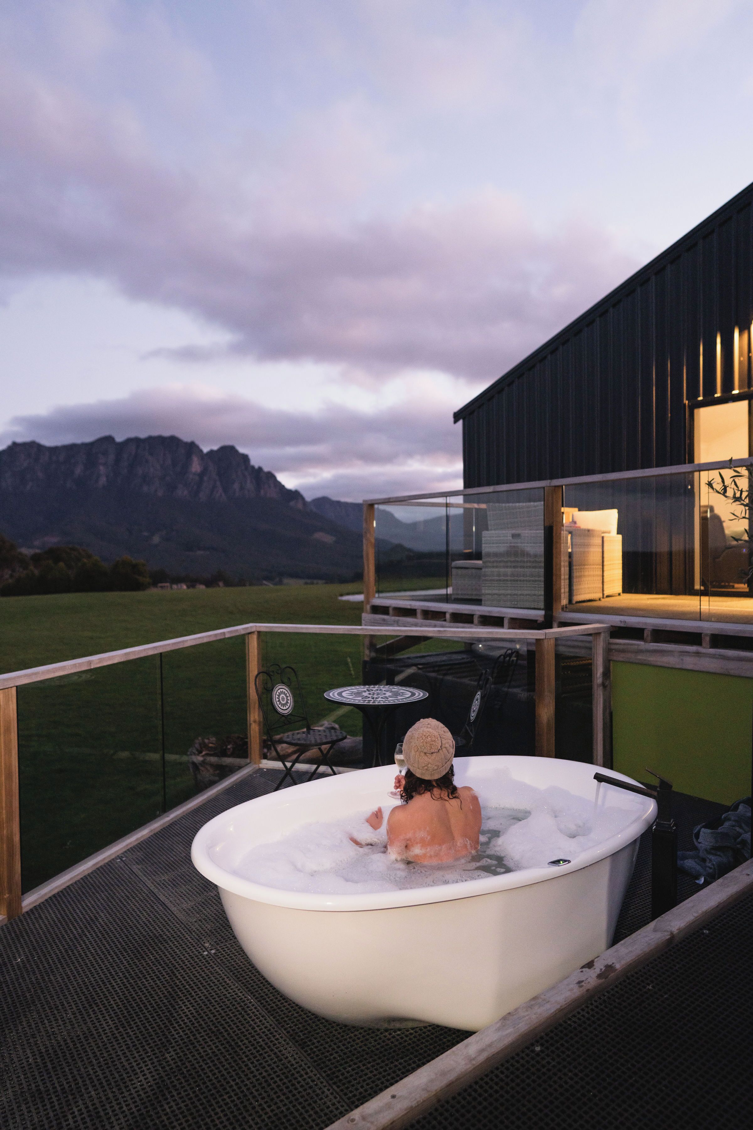 Eine Badewanne gefüllt mit Eis und ein Kürbis auf einem Balkon mit Blick auf die Berge.