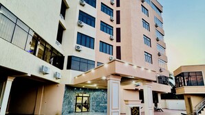 A multi-story building with a covered entrance area, air conditioning units, and a marble-tiled floor. - Hani Hotels and Suites (Benin City)