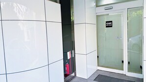 A modern building entrance with a glass door labeled "ONE STYLE". - ONE STYLE (Naha)