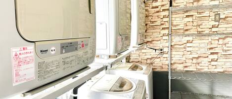 A laundry area with a white washing machine, a dryer, and a metal rack.
