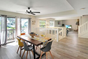 A dining area with a wooden table, chairs, and a ceiling fan.