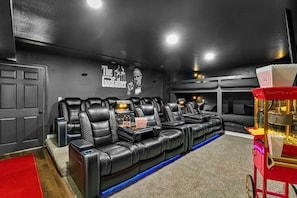 A home theater room with black leather recliners, a popcorn cart, and a wall mural of The Godfather. - Theatre~2 Hottubs~MTN Views~Hidden SpeakEasy (Swannanoa)
