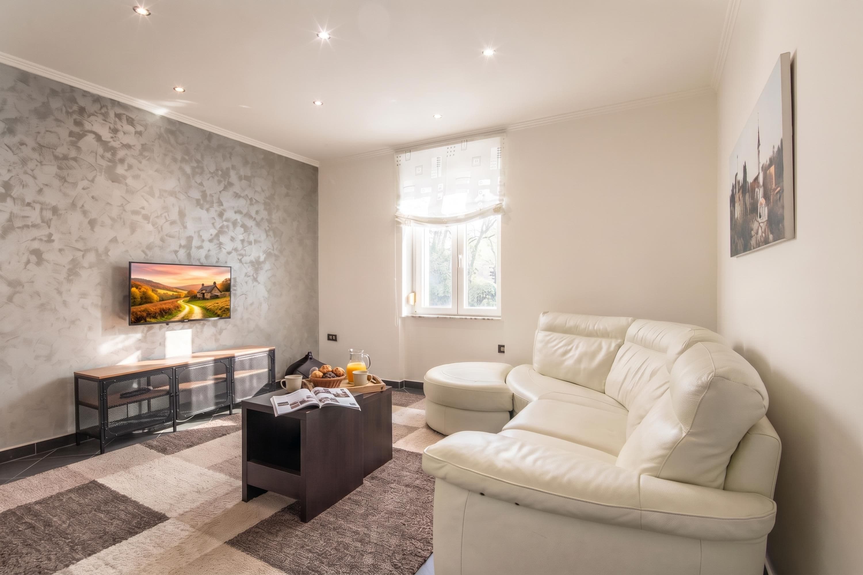 Een moderne woonkamer met een bank, een salontafel en een televisie aan de muur.