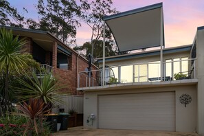 A residential property with a garage, a balcony with a metal railing, and a large window. - 3-Bed with Beach Views and Entertainment Area (Denhams Beach)