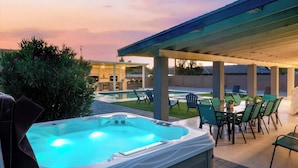 A hot tub area with outdoor seating and a covered patio. - The Palm & Putt: Heated Pool | Golden Tee | Bocce (Phoenix)