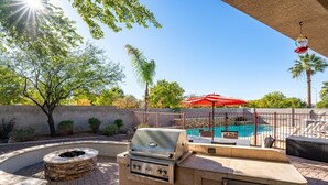 An outdoor patio with a barbecue grill, a fire pit, and a swimming pool. - Backyard Oasis | Pool, Theater & Fire Pit (Glendale)