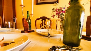 Une table à manger avec des assiettes, des couverts, une bouteille et un verre.
