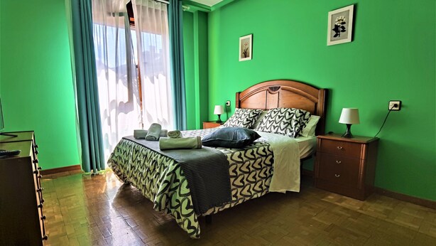 Une chambre à coucher avec un lit, des tables de chevet et une commode.