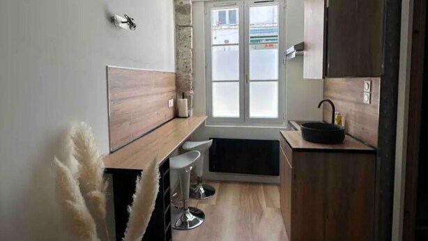 A modern kitchen with wooden cabinets, a black sink, and a window with frosted glass. - Studio Hypercentre Orléans, Entre Bord de Loire et Cathédrale (Orléans)