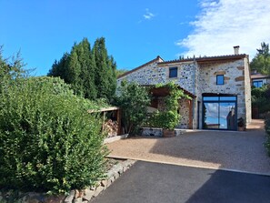 A stone house with a gravel driveway and a wooden pergola. - House in an old wine-growing village in the Allier Valley (PARENT)