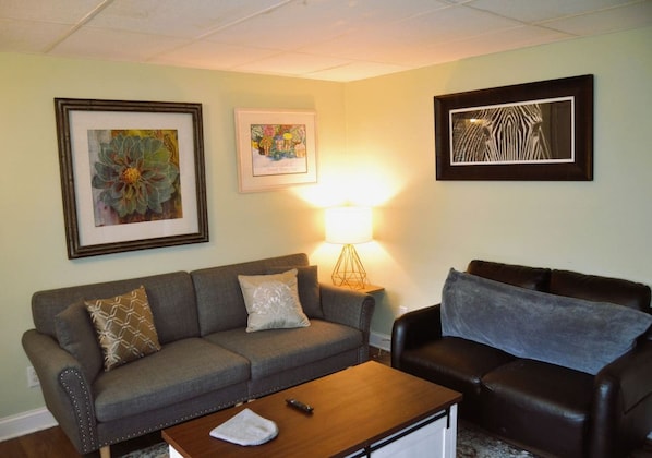 A living room with two sofas, a coffee table, and a lamp.